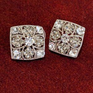 The vintage earrings are adorned with numerous clear rhinestones,